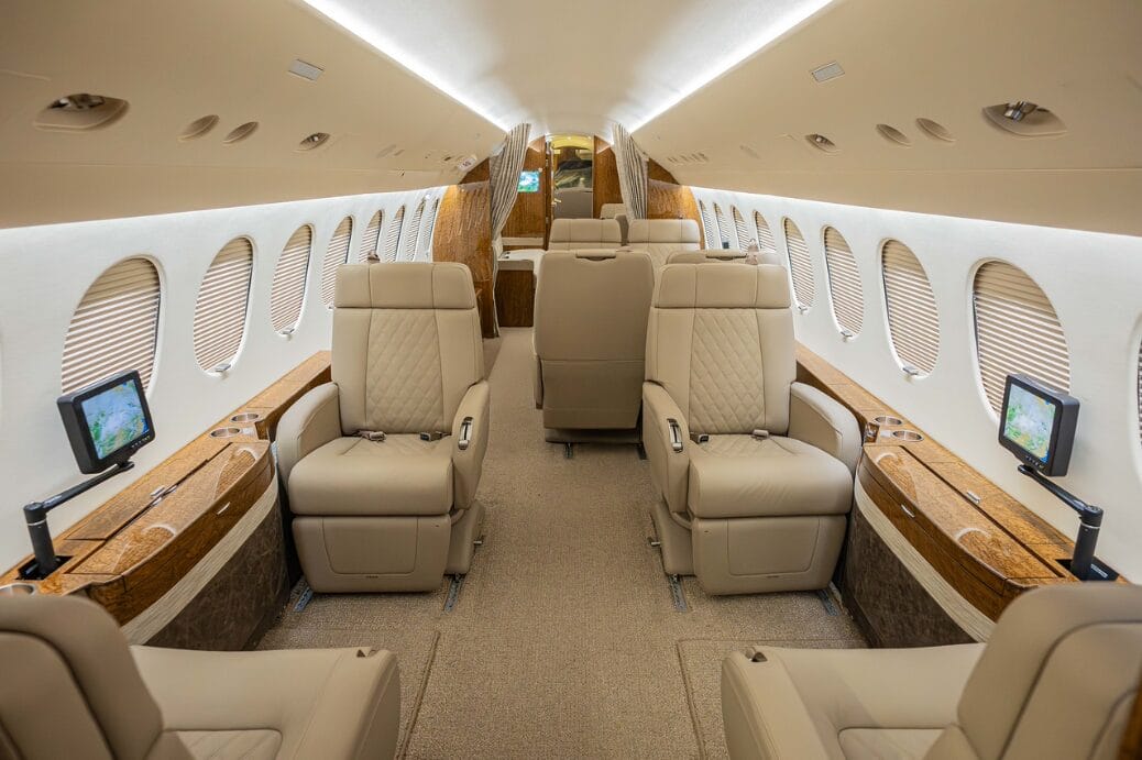 Luxury private jet interior with plush leather seats and entertainment screens.