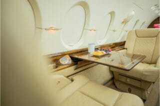 Luxury jet interior with tray table, fruit, and drink.